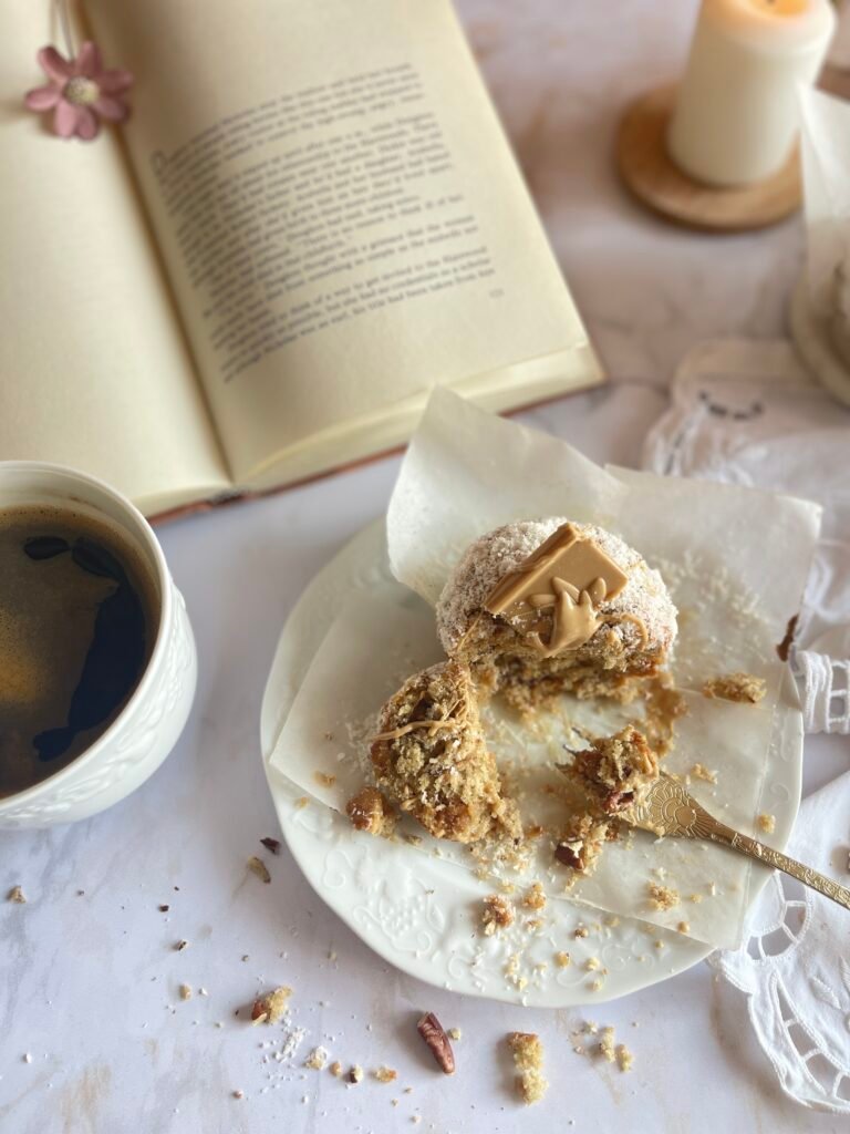 Délicieux muffins Dulcey coco et noix de pécan dans un cadre automnal, avec une tasse de café et une ambiance chaleureuse. Recette sur Deliciously Home.