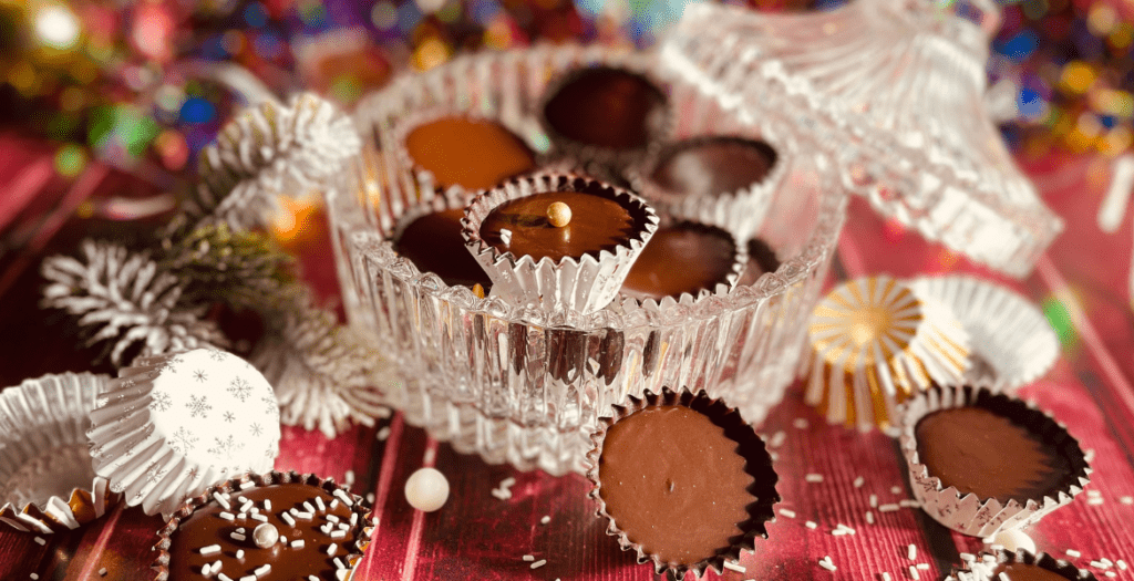 Bonbons de Noël au chocolat noir praliné faits maison, présentés dans des caissettes en aluminium rétro pour une ambiance festive. Recette sur Deliciously Home.