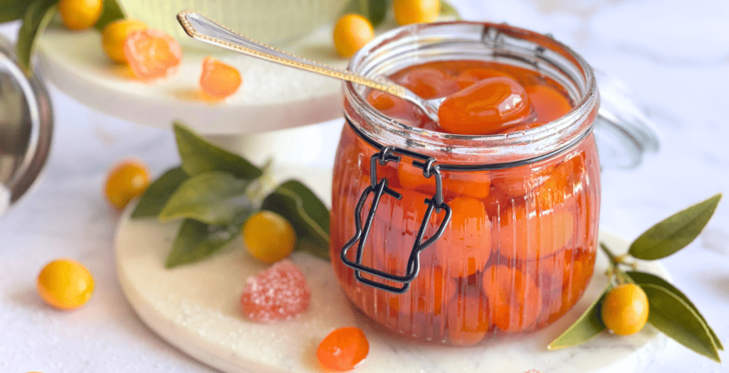 Délices ensoleillés : kumquats confits faits maison baignés dans leur sirop doré sur deliciouslyhome.com.