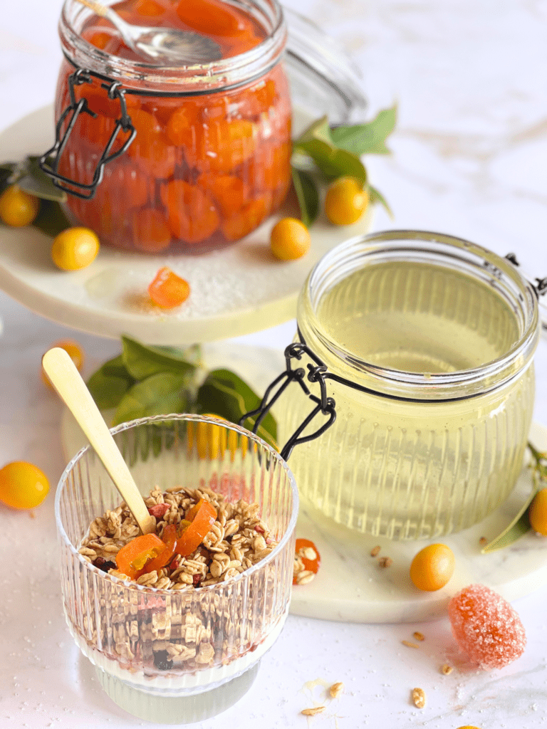 Kumquats confits faits maison et leur sirop délicat, prêts à sublimer les moments gourmands de la journée, du petit-déjeuner aux desserts, sur deliciouslyhome.com.