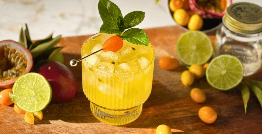 Mocktail kumquat servi avec glace, menthe fraîche et fruit de la passion – recette rafraîchissante à découvrir sur www.deliciouslyhome.com