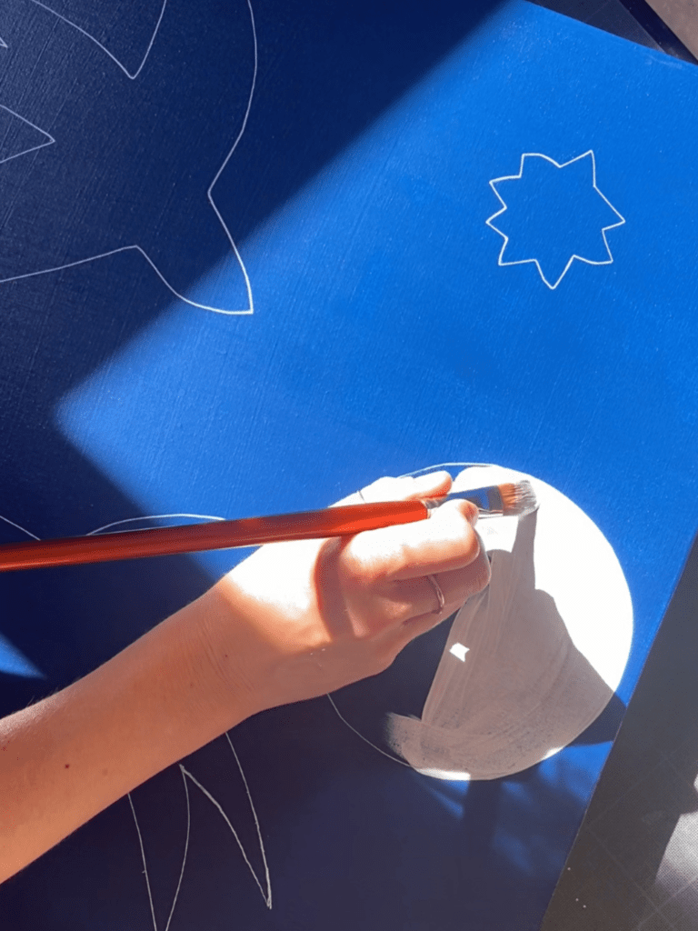Moment de création : peindre à la main un oiseau blanc sur fond bleu, esquissé au crayon pour un projet inspiré de Matisse – Happy Hours Créatifs