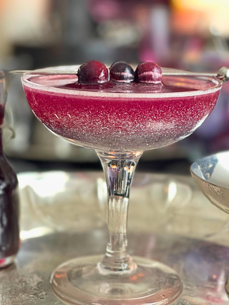 blueberry sour cocktail deliciouslyhome article3 Zoom sur un whiskey sour à la myrtille, texture brillante et garniture fruitée, cocktail d’Halloween sur Deliciously Home.