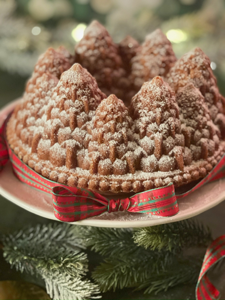 Cake de Noël à la vanille moulé en sapins, mis en scène pour les fêtes. Retrouvez la recette détaillée sur Deliciously Home.