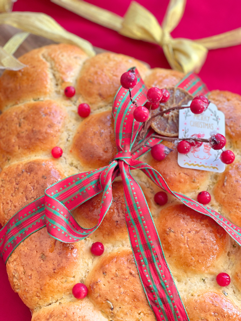Pain moelleux de Noël à la courgette et au cheddar, décoré d’un ruban rouge et vert, recette salée conviviale signée Deliciously Home.