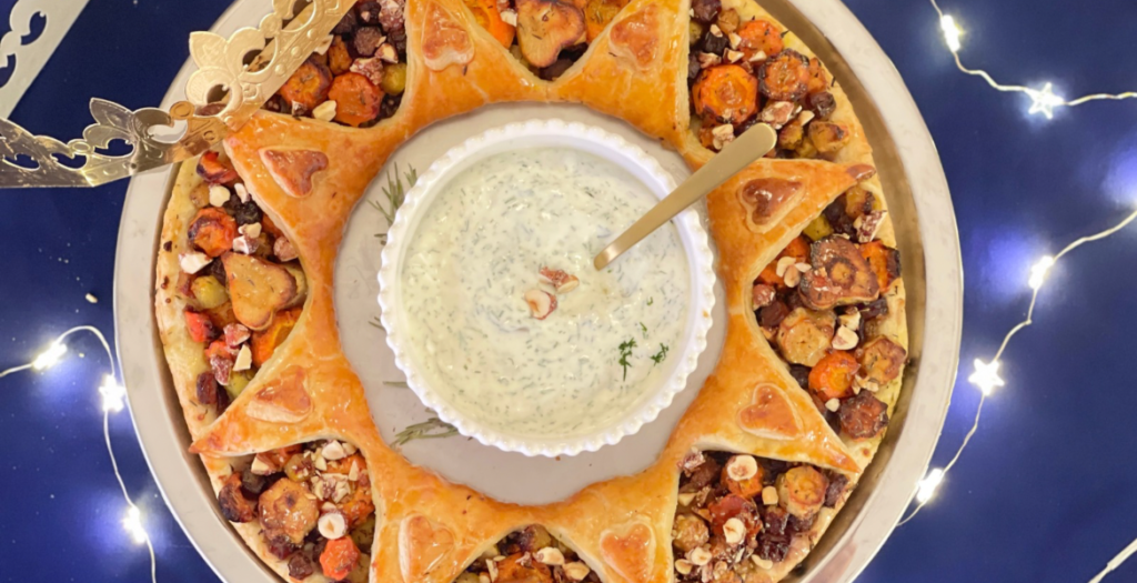 Présentation festive d’une couronne des rois salée aux légumes d’hiver rôtis et sauce au yaourt. Article et recette disponibles sur Deliciously Home.