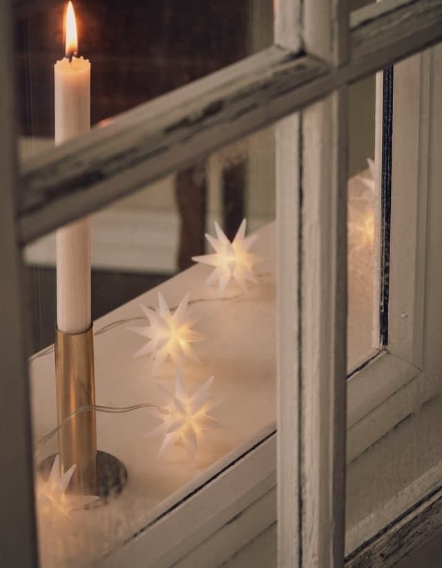 soft minimalism white winter deliciouslyhome 18 Bougie blanche et petites étoiles lumineuses posées sur un rebord de fenêtre. Lumière douce et décor d’hiver poétique selon Deliciously Home