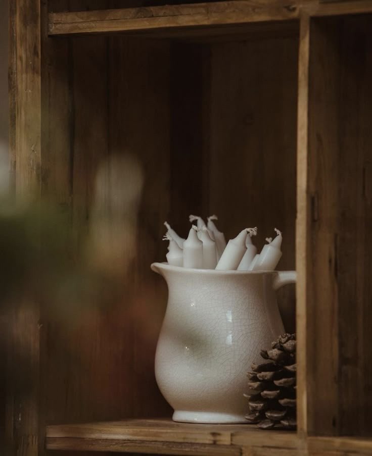 soft minimalism white winter deliciouslyhome 2 Cruche en céramique blanche contenant des bougies, posée sur une étagère en bois brut. Minimalisme chaleureux et textures naturelles, article à lire sur Deliciously Home