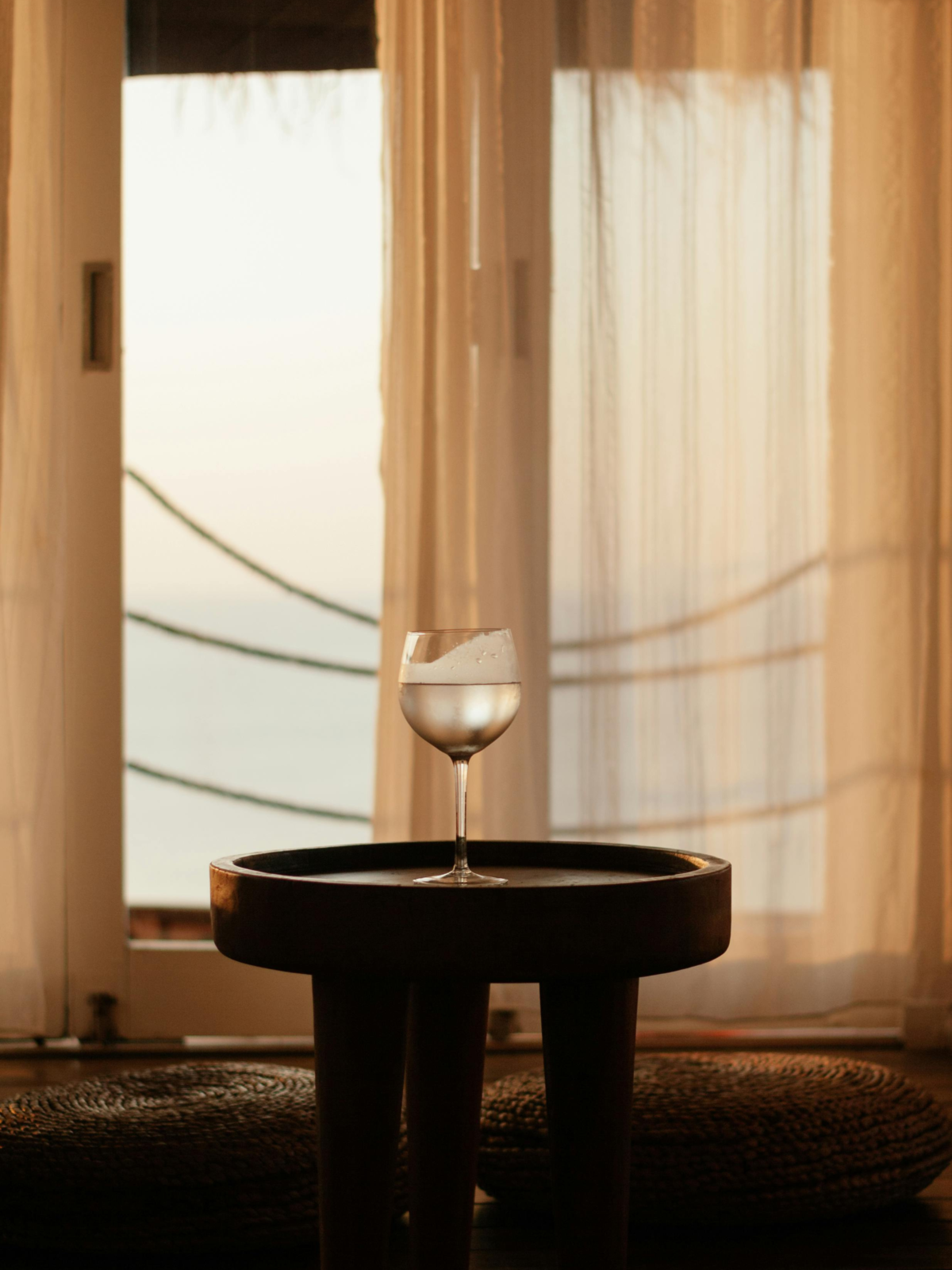 ambiance interieur saison chez soi deliciouslyhome Petite table ronde devant des rideaux baignés de lumière naturelle, ambiance maison douce et minimaliste. Découvrez nos inspirations décoration intérieure sur Deliciously Home.