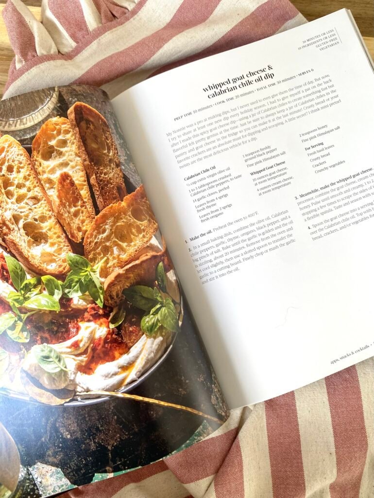 Livre Half Baked Harvest: Quick & Cozy ouvert sur une recette de dip au fromage de chèvre fouetté, servi avec du pain croustillant.