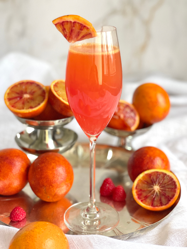 Cocktail mimosa à l’orange sanguine et sirop de framboise, idéal pour un brunch gourmand, recette à découvrir sur Deliciously Home.