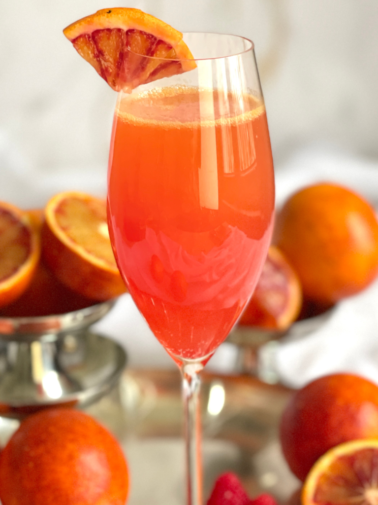 Mimosa à l’orange sanguine avec sirop de framboise, parfait pour le brunch, cocktail à découvrir sur Deliciously Home.