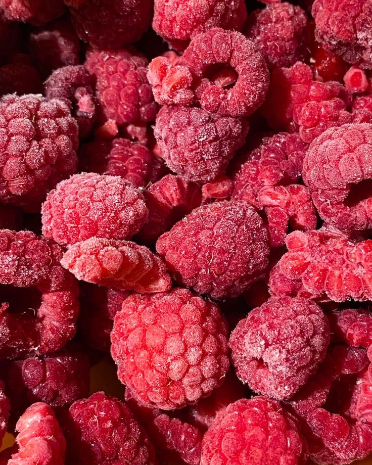 Framboises surgelées en gros plan dans des tons rouge et rose