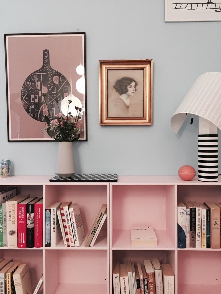 Bibliothèque murale rose avec cadres et décoration