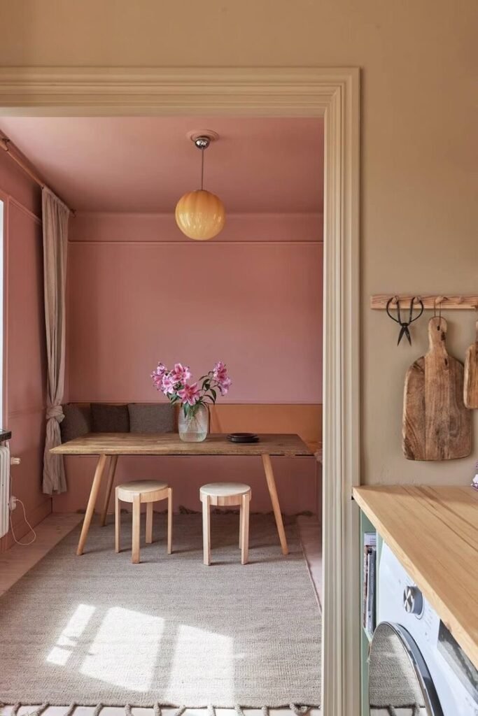 Coin repas avec murs roses et mobilier en bois