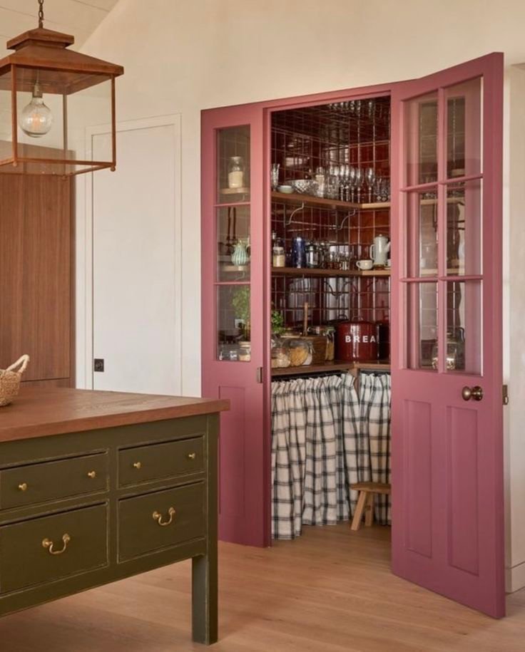 Cuisine lumineuse avec porte de pantry rose
