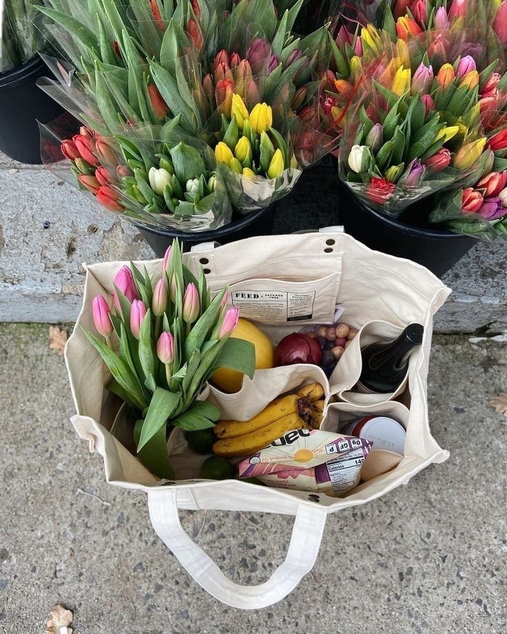 Sac de courses avec tulipes roses devant un étal de fleurs