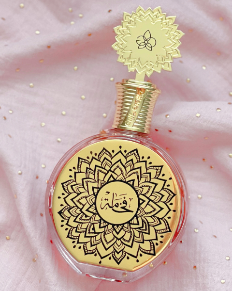 Parfum Fakhama de Maison Asrar sur tissu rose lumineux, signature olfactive de mars sur Deliciously Home, gourmand floral inspiré de Love Don’t Be Shy