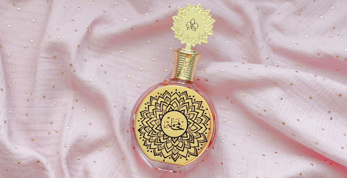 Parfum Fakhama de Maison Asrar sur tissu rose lumineux, signature olfactive de mars sur Deliciously Home, gourmand floral inspiré de Love Don’t Be Shy