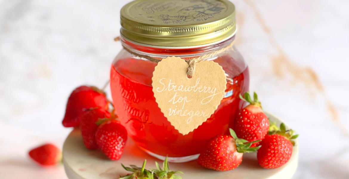 Vinaigre de parures de fraises maison en bocal, réalisé à partir des chutes de fraises dans une démarche zéro déchet, idéal pour découvrir la fermentation naturelle et les recettes anti-gaspillage sur notre blog Deliciously Home.