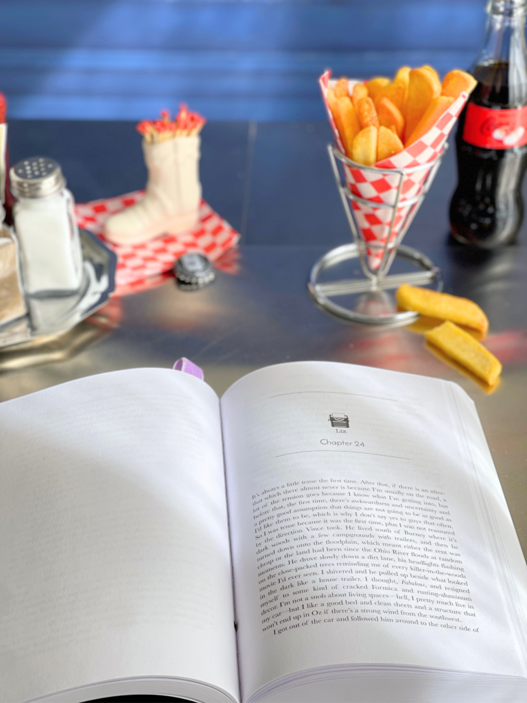 Lavender’s Blue de Jennifer Crusie et Bob Mayer ouvert sur un chapitre dans un décor de diner américain, tome 1 de la série Liz Danger. Sélection lecture fiction d'avril.