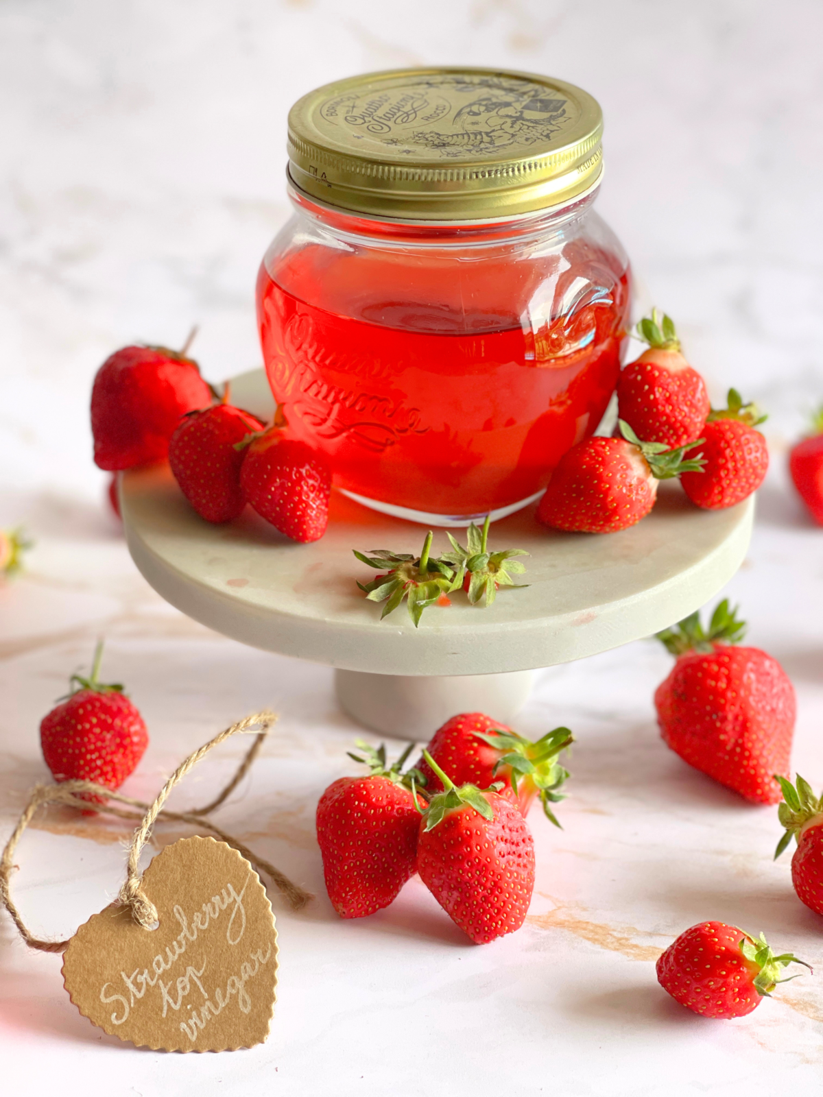 Recette de vinaigre de parures de fraises maison présentée avec des fraises fraîches, illustration d’une technique simple de recyclage des déchets alimentaires en condiment fruité sur notre blog Deliciously Home.