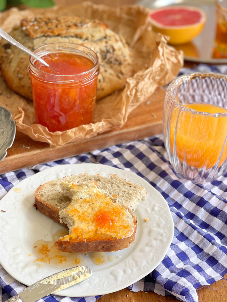 Confiture de pamplemousse au miel de lavande servie sur une tranche de pain au petit-déjeuner, une recette Deliciously Home aux saveurs d’agrumes et de lavande.