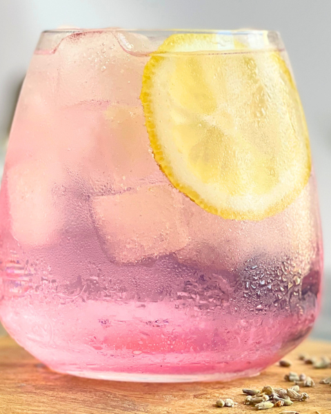 Cocktail gin tonic lavande floral servi sur glace avec une tranche de citron. Une recette estivale et botanique imaginée par Deliciously Home.