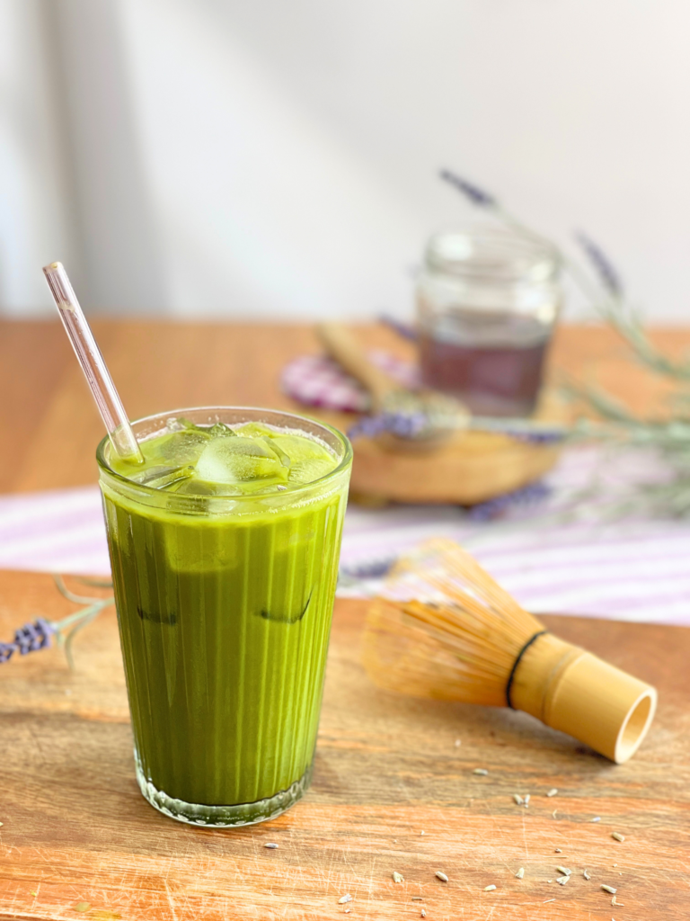 Verre de matcha latte lavande glacé servi avec lait végétal, glaçons et matcha fouetté. Une boisson inspirée des coffee shops réalisée par Deliciously Home.
