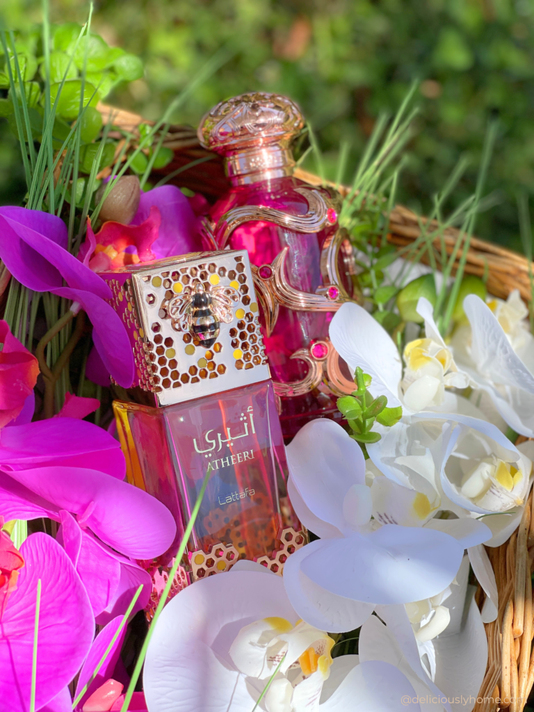 Atheeri de Lattafa photographié par Deliciously Home parmi des orchidées roses et blanches. Une illustration de l'élégance florale et de la fraîcheur lumineuse qui ont marqué notre mois de mai.