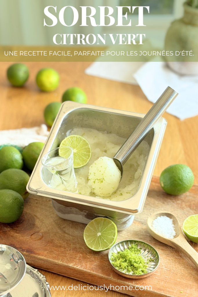 Pin Pinterest présentant une recette de sorbet au citron vert maison. Un bac en inox rempli de sorbet est entouré de citrons verts, de zestes et de fleur de sel. Le texte annonce une recette facile, parfaite pour les journées d'été. Découvrez la recette complète sur Deliciously Home.