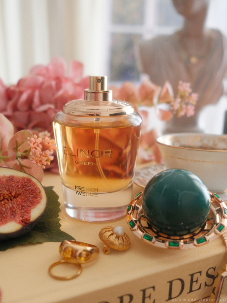 Elinor Green de French Avenue avec son capuchon bijouté, entouré de figue, de fleurs et d’une tasse de thé, évocation de ses facettes fruitées, crémeuses et boisées sur Deliciously Home.