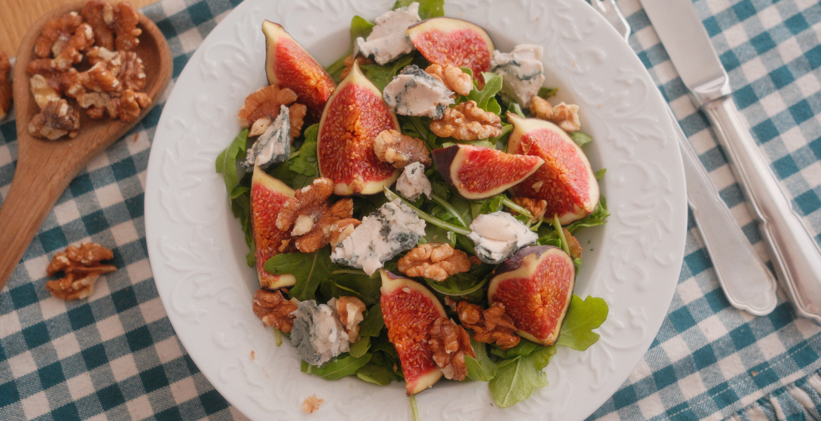 Vue de dessus d’une salade de figues violettes, fromage bleu, cresson et noix torréfiées. Retrouvez la recette sur Deliciously Home.