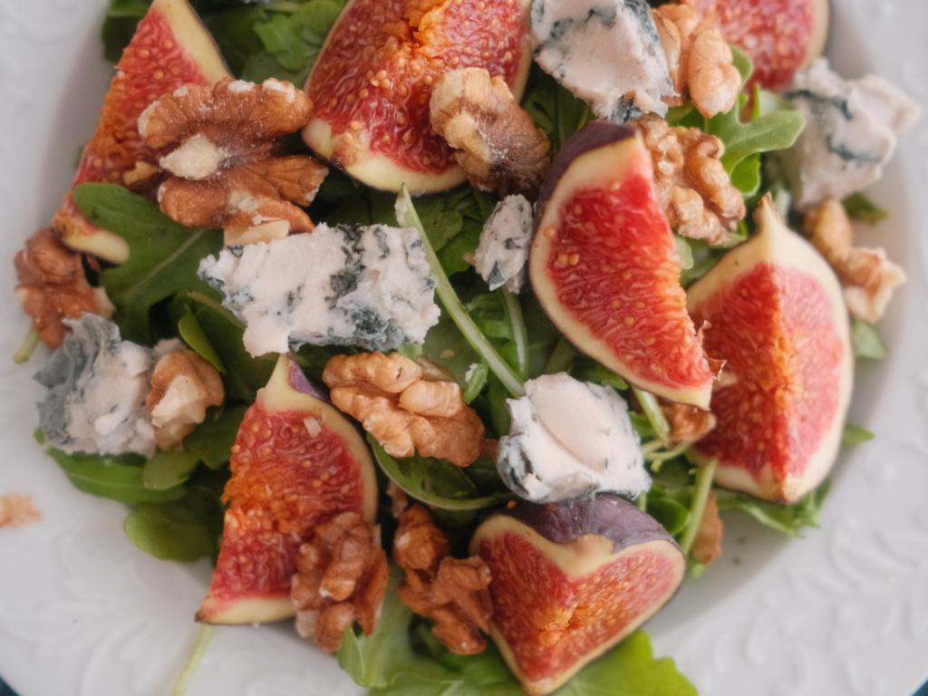 Salade de figues fraîches coupées en quartiers, fromage bleu, cresson et noix torréfiées. Retrouvez la recette sur Deliciously Home.
