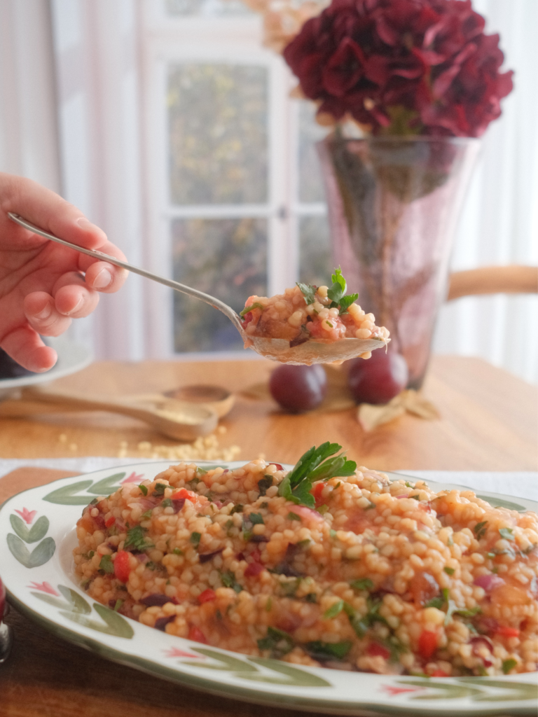 Cuillerée de taboulé aux prunes violettes, couscous à gros grains et herbes fraîches, prête à être dégustée. Retrouvez la recette sur Deliciously Home.