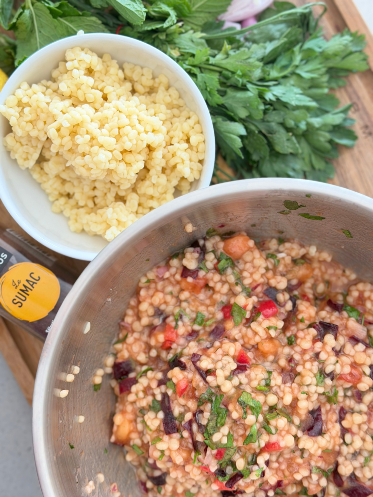 Taboulé de fin d’été aux prunes violettes, couscous à gros grains, herbes fraîches, oignon rouge et piment, prêt à être servi. Retrouvez la recette sur Deliciously Home.